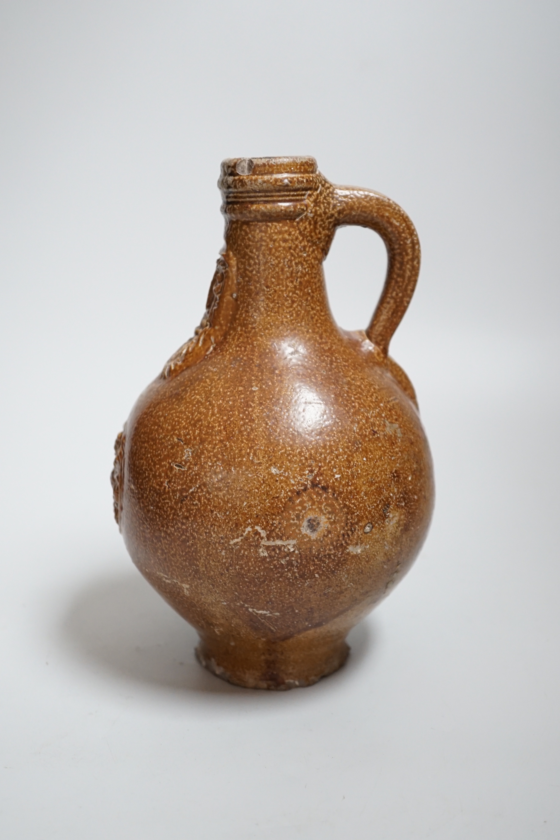 A 17th century stoneware Bellarmine or Bartmann jug, 21cm
